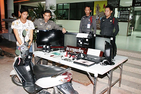 Police bring out for the cameras Ampol Saree (left), accused of stealing the Yamaha Mio and electronic equipment displayed in front of him.